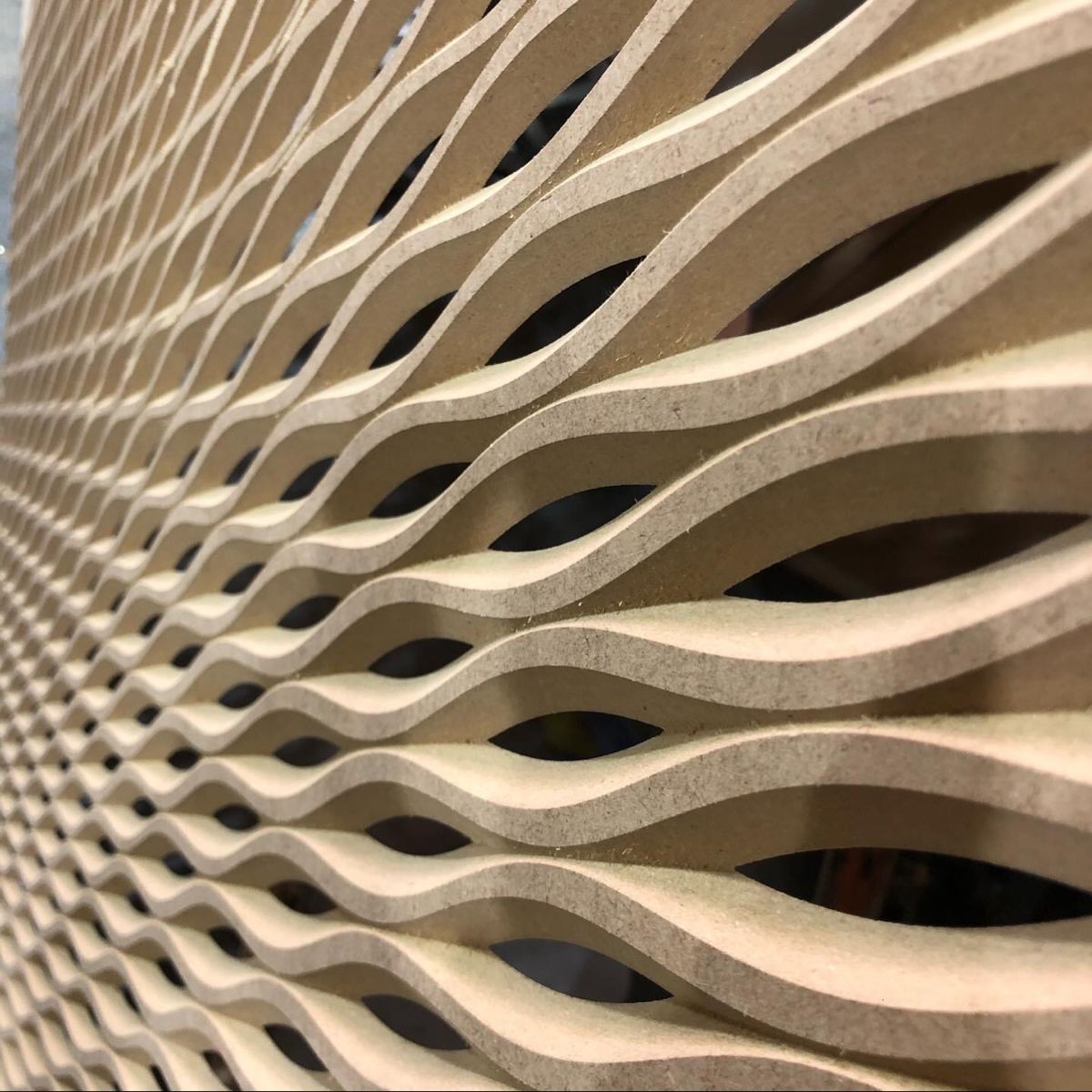 Panel arquitectónico decorativo con diseño de ondas fabricado en CNC.